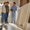Een stel bekijkt samen met de aannemer het uitgevoerde isolatiewerk in hun woning.