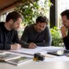 Het team van binnenafbouwspecialisten buigt zich samen over de bouwtekening.