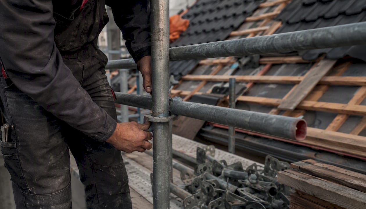 Werknemers zijn bezig met het opbouwen van steigers op de bouwplaats.