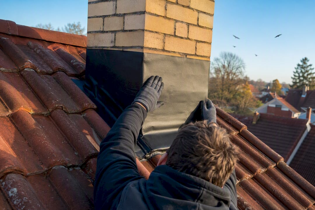 Dakdekker brengt EPDM aan rondom de schoorsteenvoet